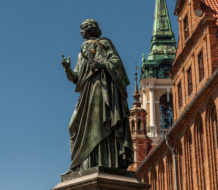 The Nicolaus Copernicus Monument in the astronomer's home town of Toruń, Poland. Copernicus, famous for developing a heliocentric model of the universe, was a devout Catholic.